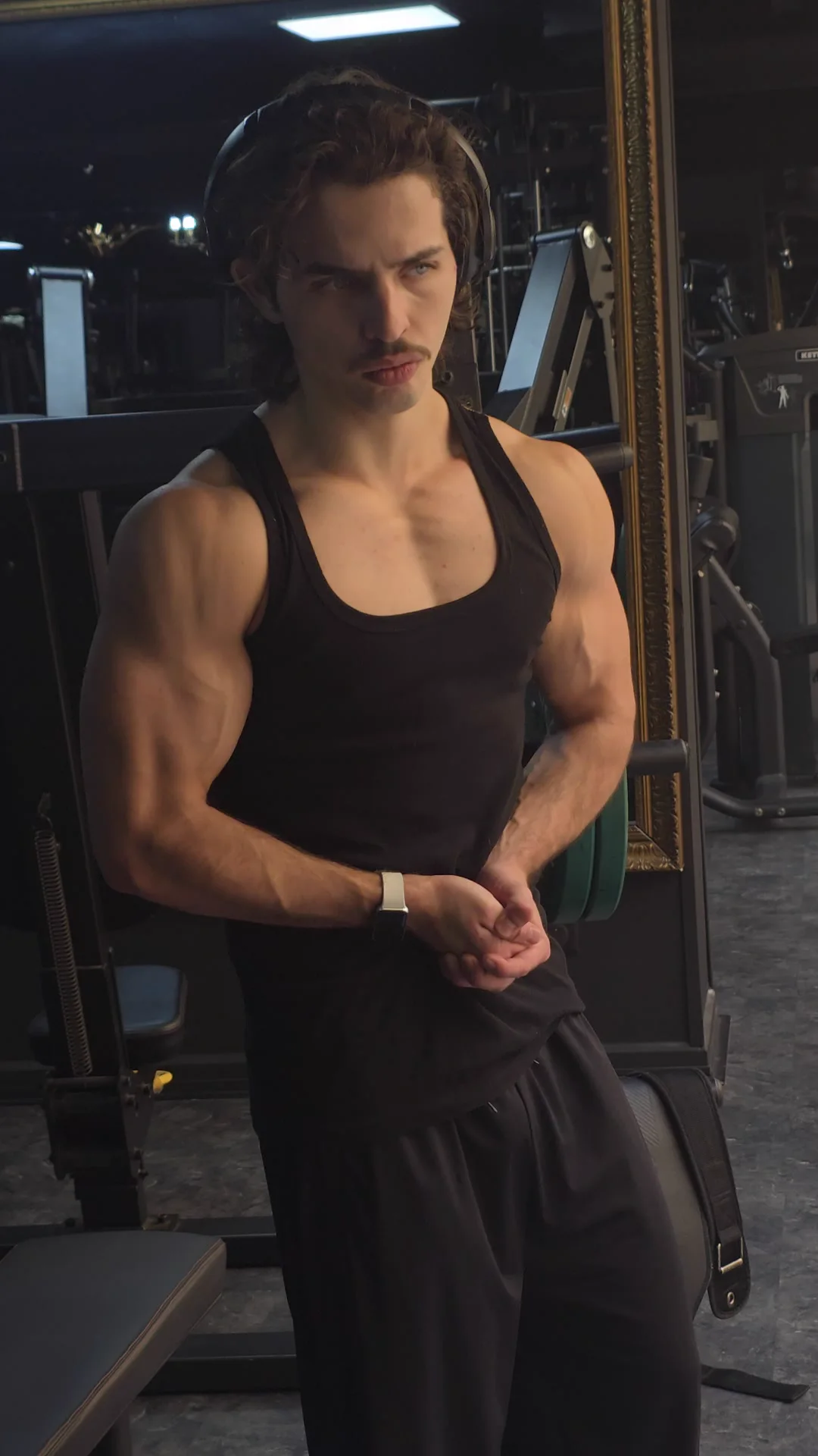 Rayan à la salle de sport, en débardeur noir